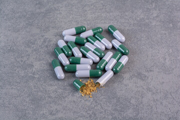 Open capsule pill falling out molecules on marble background
