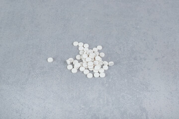 A lot of white circle pills on gray background