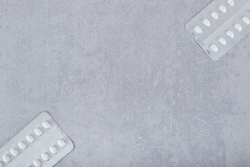 Two blisters with pills on a gray background