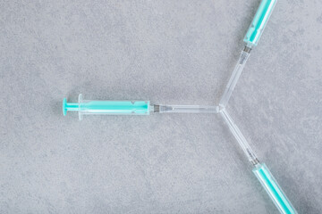 Three empty syringes on gray background