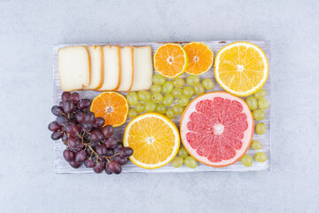 A wooden board full of sliced fruits and bread