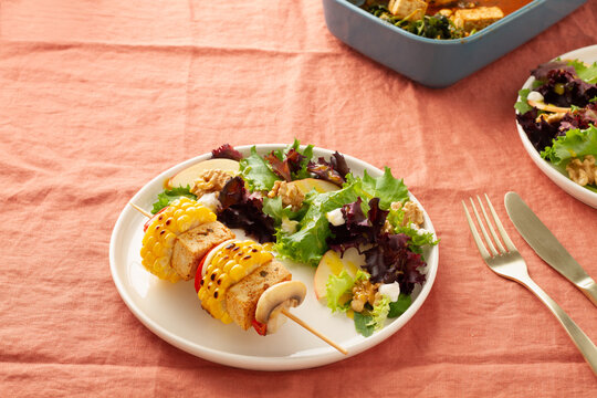 Vegan plate with vegetable skewer with tofu served and salad