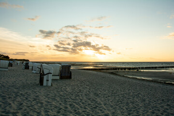 Fototapeta na wymiar Sunset over the sea with beach chairs on the sandy beach