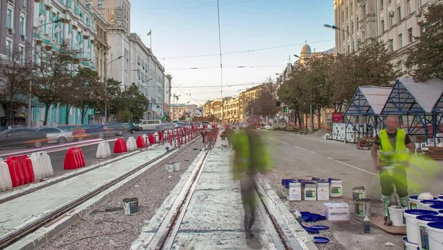 Tram rails at the stage of their integration into concrete plates on the road timelapse. Workers make mix and filling by liquid resin for reduction of vibration and noice. The process of