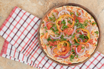Round pita bread with peppers and onion on wooden plate