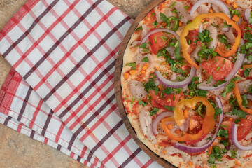 Round pita bread with peppers and onion on wooden plate