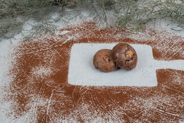 Chocolate cookies with powdered cocoa on white background