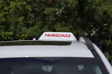 A driver school sign in german (Fahrschule) on a car. 