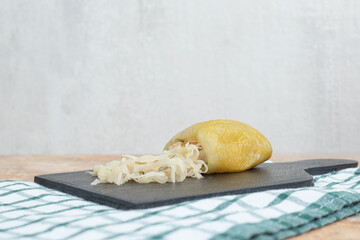 Pickled peppers stuffed with sauerkraut on dark board