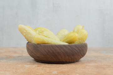 Crunchy pickled cucumbers in wooden bowl