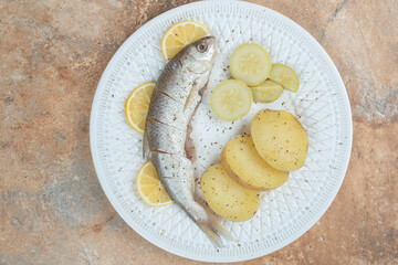 Herring with boiled potatoes on white plate