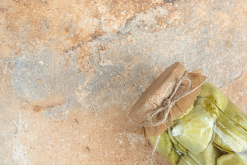 A jar of pickled vegetables on marble background