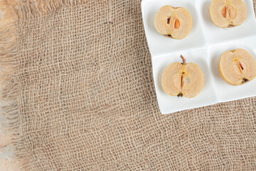 Pickled green plums on white plate