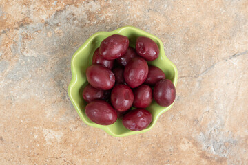 Pickled cornel cherries in green bowl