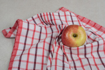 Whole red apple on striped tablecloth