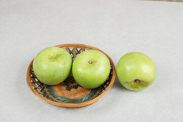 Fresh green apples in wooden basket