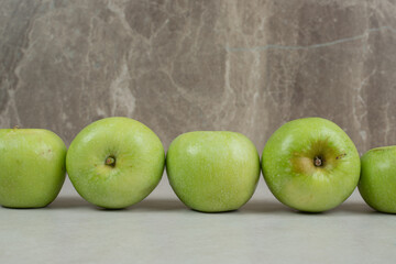 Whole green apples on marble background