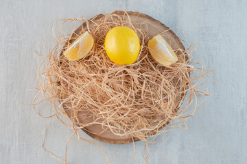 A wooden board with whole and sliced lemon
