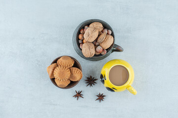 A cup of coffee with nuts and cookies