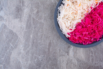 Sauerkraut and red cabbage on black wooden board