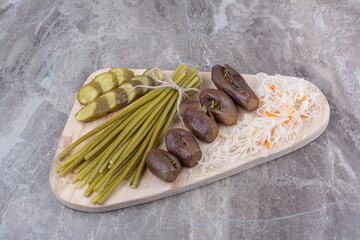 Assortment of homemade pickles on wooden board