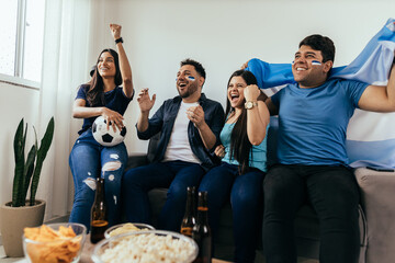 Football fans friends watching Argentina national team in live soccer match on TV at home