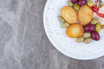 Roasted potato and various pickles on white plate