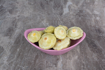 Various pickled fruits in pink bowl