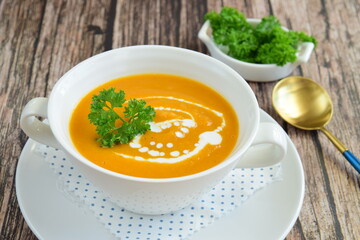 Pumpkin soup with coconut milk with parsley. Wooden background
