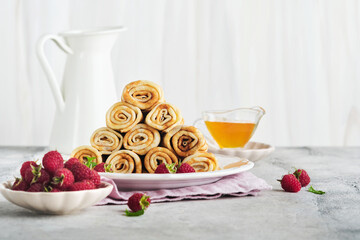Pancakes. Stack of crepes or thin pancakes with berries, with raspberries and honey for breakfast. Homemade breakfast. Copy space. Selective focus.