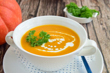 Pumpkin soup with coconut milk with parsley. Wooden background