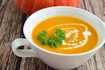 Pumpkin soup with coconut milk with parsley. Wooden background