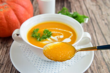 Pumpkin soup with coconut milk with parsley. Wooden background