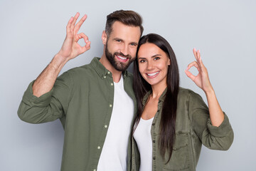 Photo of young cheerful couple show fingers okey symbol recommend promo ideal isolated over grey color background