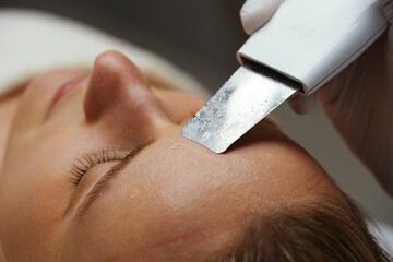 Ultrasonic cleaning of women's skin in a beauty salon.