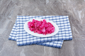 Pickled red cabbage on white plate with tablecloth