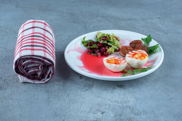 A breakfast platter next to a neatly wrapped towel on marble background