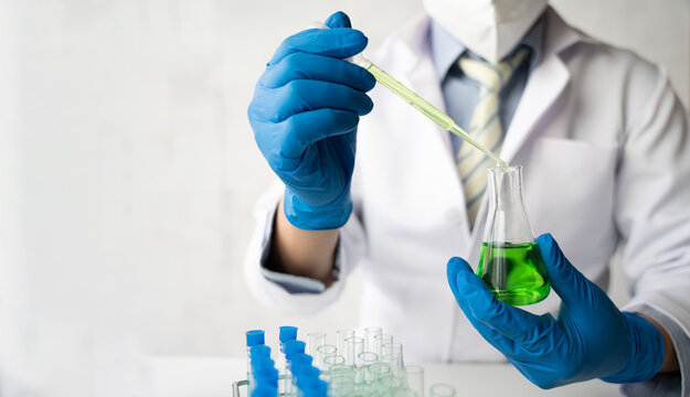 Scientist working at the laboratory, doctor looking at a test tube of clear solution in a laboratory.