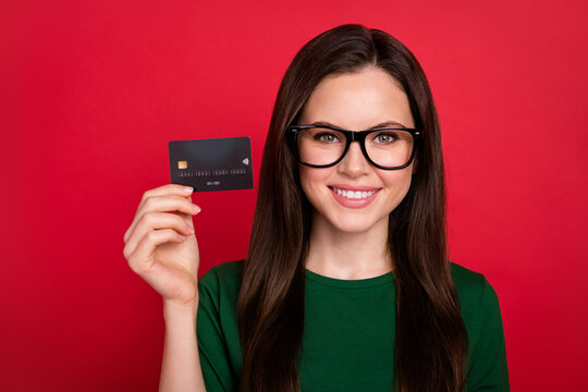 Photo of attractive girl bank employee credit card promo wear trendy green clothes eyeglasses isolated on bright red color background