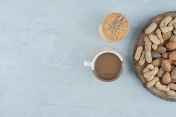 A cup of coffee with various nuts and cookies