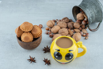 A cup of coffee with nuts and cookies