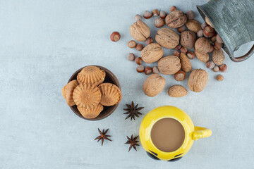 A cup of coffee with nuts and cookies