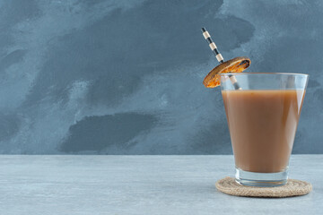 A glass of aroma coffee with straw and dried orange