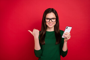 Naklejka premium Photo of nice girl hairdo direct empty space sale device poster dressed trendy green clothes eyewear isolated on bright red color background
