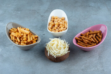 Three colorful plates of delicious snacks with wooden bowl full of cheese