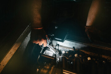 Fototapeta na wymiar repair and replacement of fuel injectors of the car, the master unscrews the fuel injector.