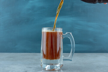 A glass of light delicious beer on blue background