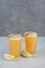 Two glasses of beer with fish and sliced lemon