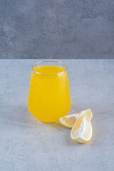 Fresh glass of lemonade with sliced lemon on gray background