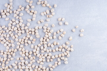 Chickpeas scattered about in a messy manner on marble background